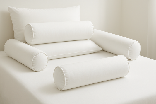 Multiple White Bolster Cushions on Bed